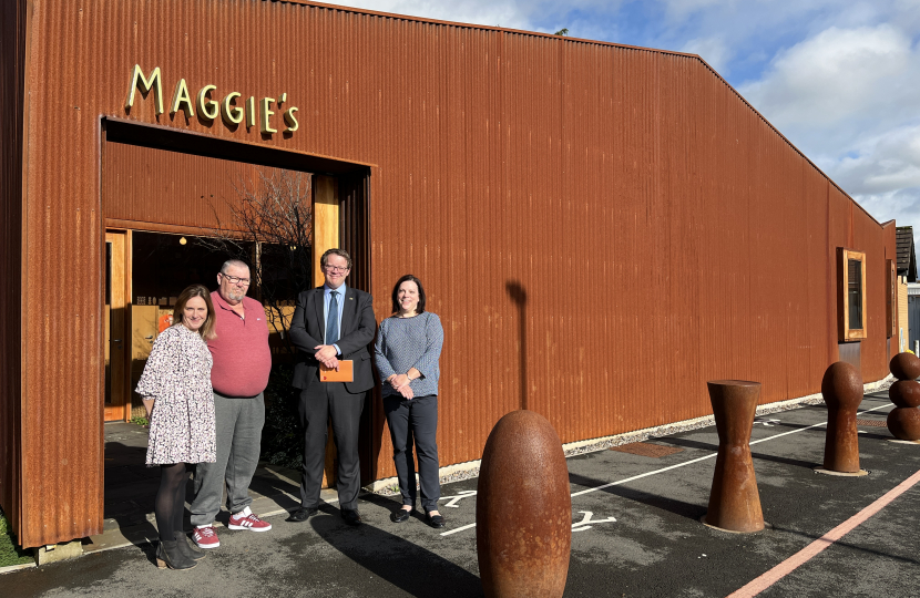 Joel standing with volunteers of Maggie's outside their facility in Whitchurch