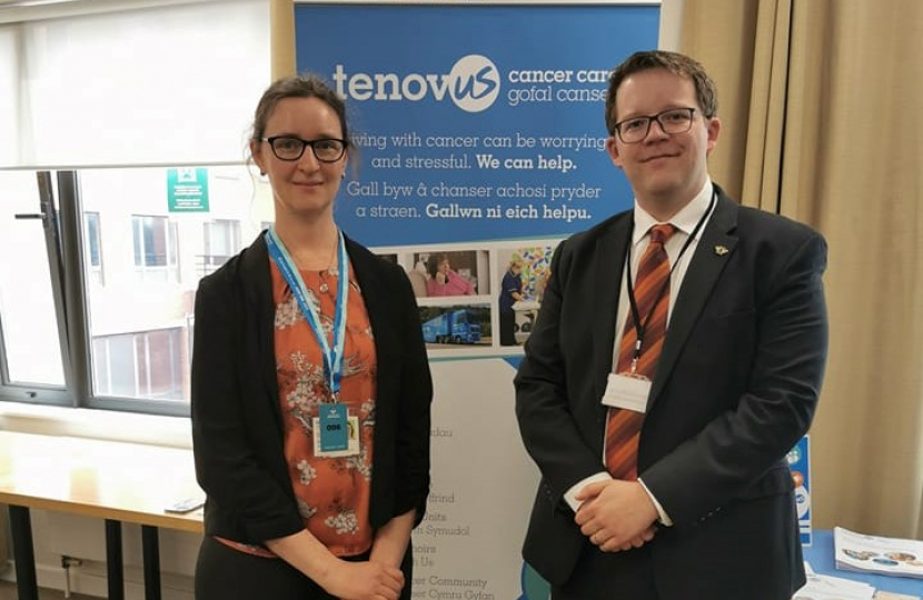 Joel James with a representative from Tenovus Cancer Care in the Senedd