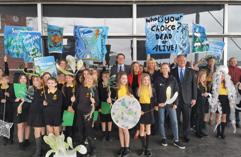 Joel James outside the Welsh Parliament with children from St. Peter's Primary School