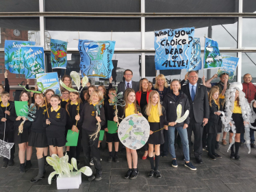 Joel James outside the Welsh Parliament with children from St. Peter's Primary School